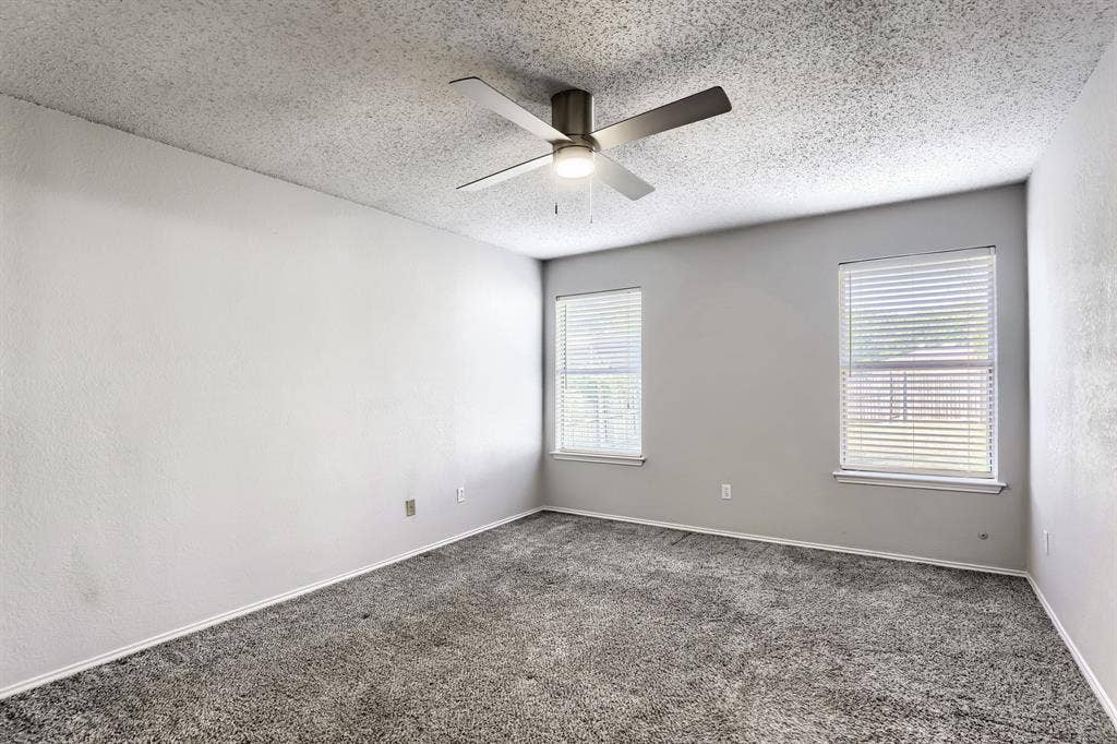 2039 Angelica Way, Dallas, TX 75217 Room featuring neutral wall tones, gray carpeting, dual windows with fitted blinds, and a central ceiling fan with integrated lighting