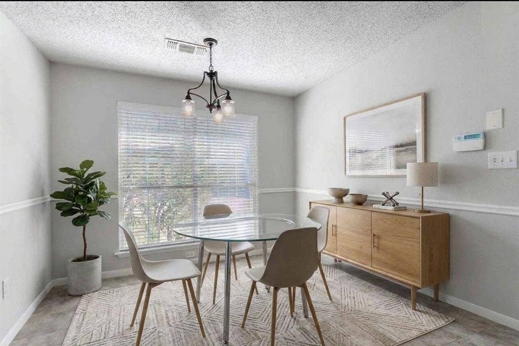 2039 Angelica Way, Dallas, TX 75217 Virtually Staged - Multi-pane window with horizontal blinds, three-light metal chandelier, and white chair rail molding