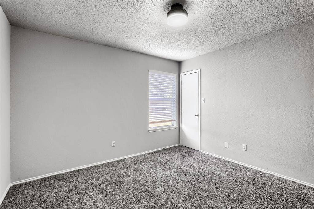 2039 Angelica Way, Dallas, TX 75217 Neutral-toned carpeted flooring, textured ceiling, flush-mount light fixture, single-panel interior door, and window with white blinds