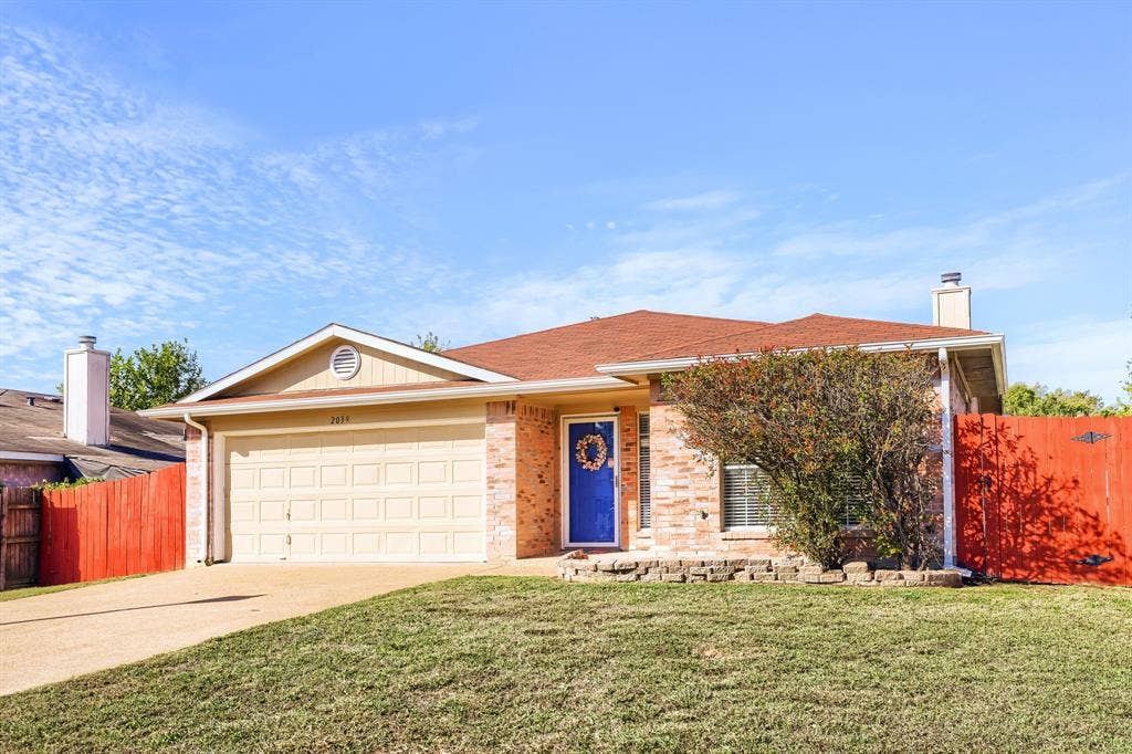 2039 Angelica Way, Dallas, TX 75217 Single-story brick and siding exterior featuring an attached two-car garage, a concrete driveway, and an opaque red perimeter fence