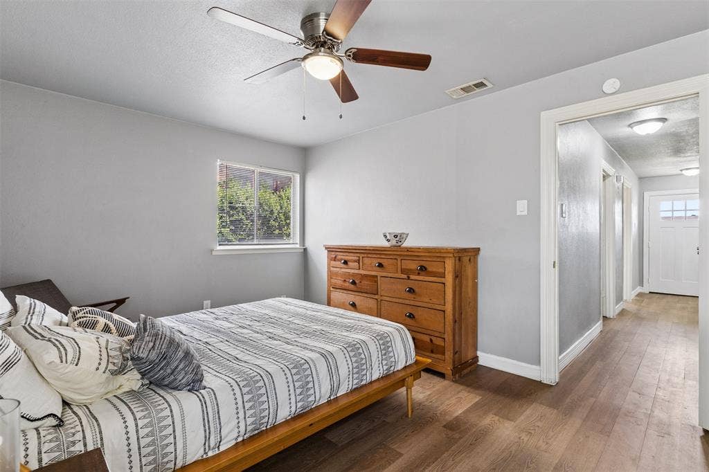 Neutral wall tones, wood-finish flooring, and a ceiling fan with integrated lighting