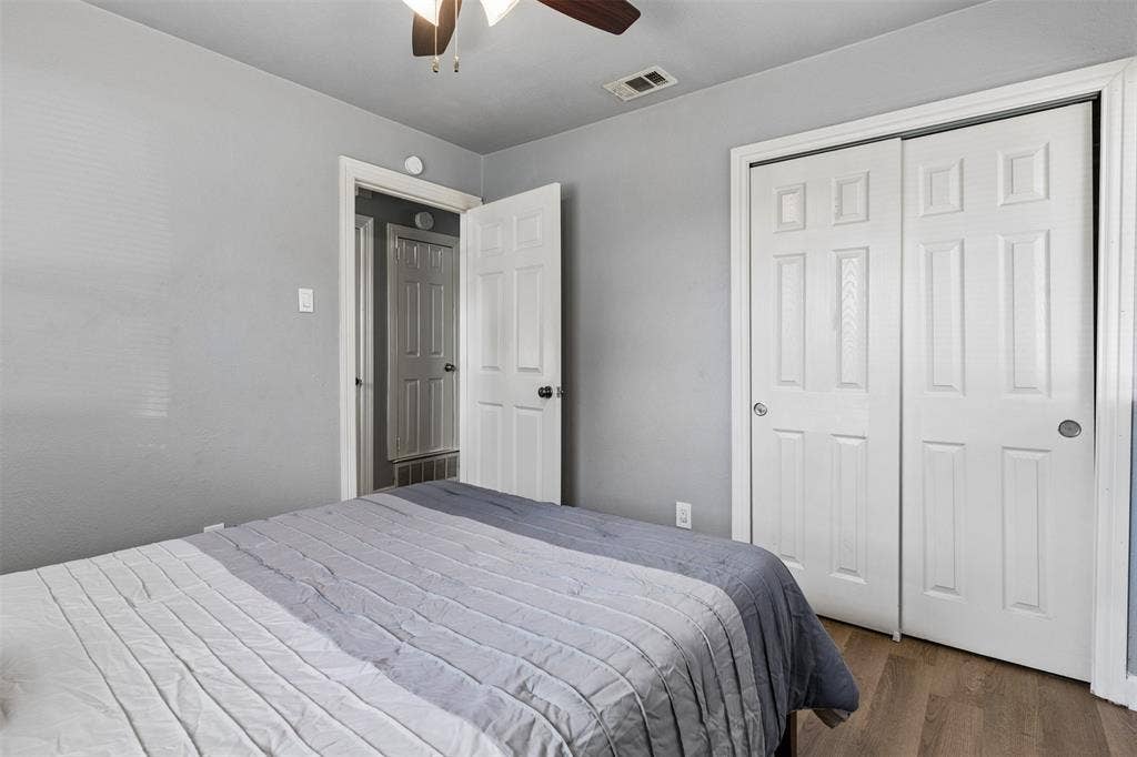 Neutral-toned interior featuring wood-finish flooring, dual-panel interior doors, and a ceiling-mounted fan