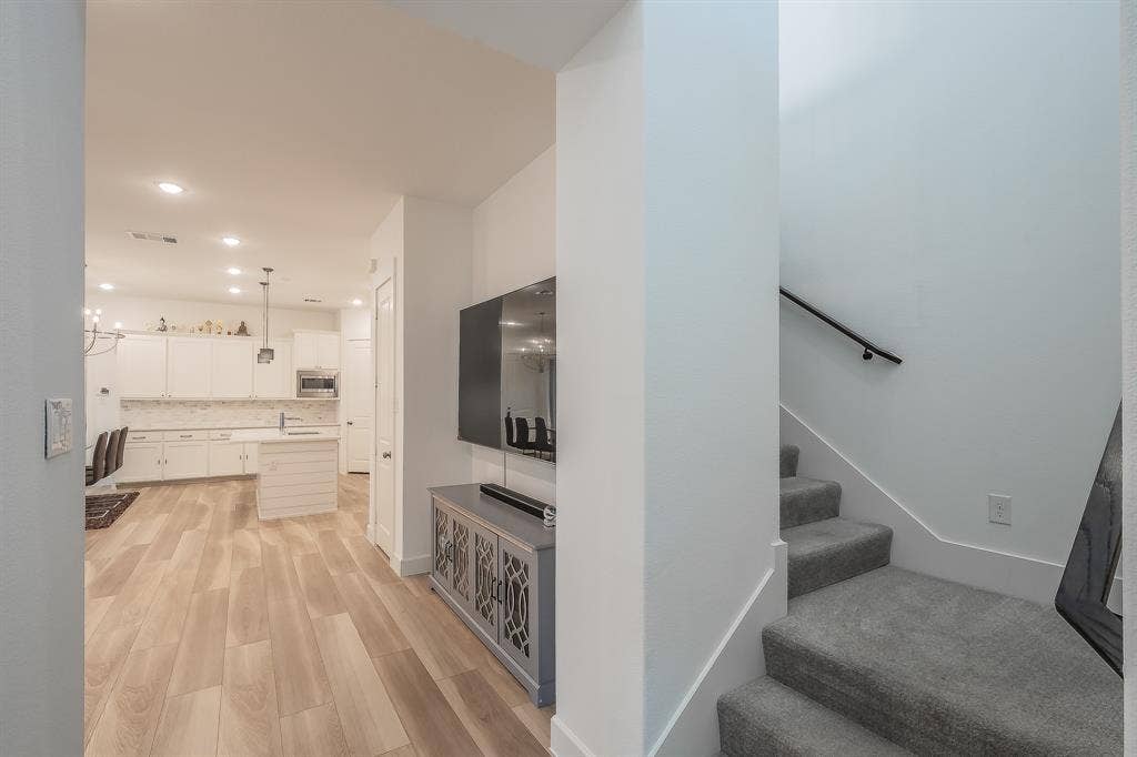 stairway near the front door leads to a powder bathroom for guests and upstairs to the game room and bedrooms