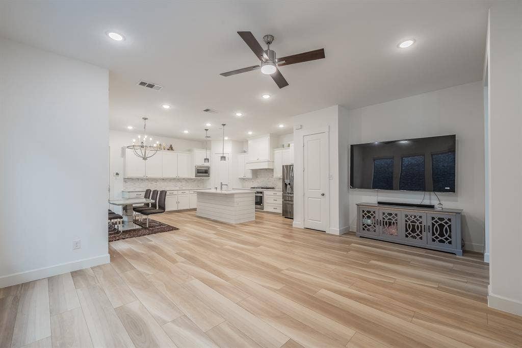 Open-concept living room opens to dining area and kitchen and a recessed area perfect for a media cabinet