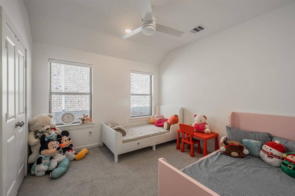 Second of 2 secondary bedrooms features ceiling fan, large windows and a walk-in closet