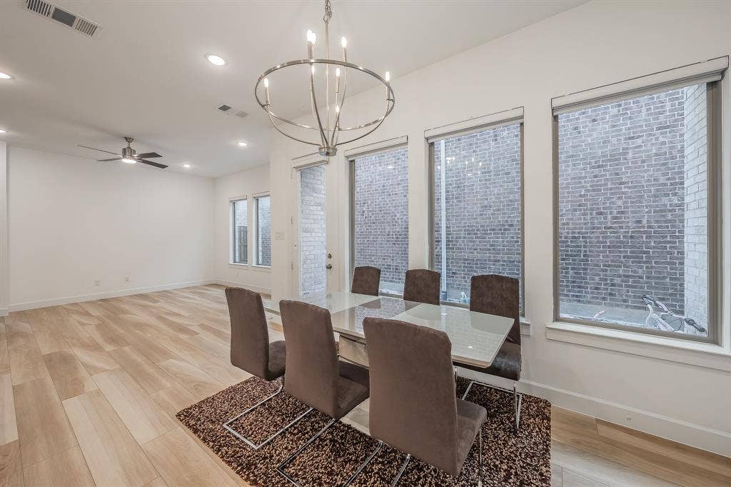 Open-concept dining near large windows for natural light and next to the side patio, perfect for grilling