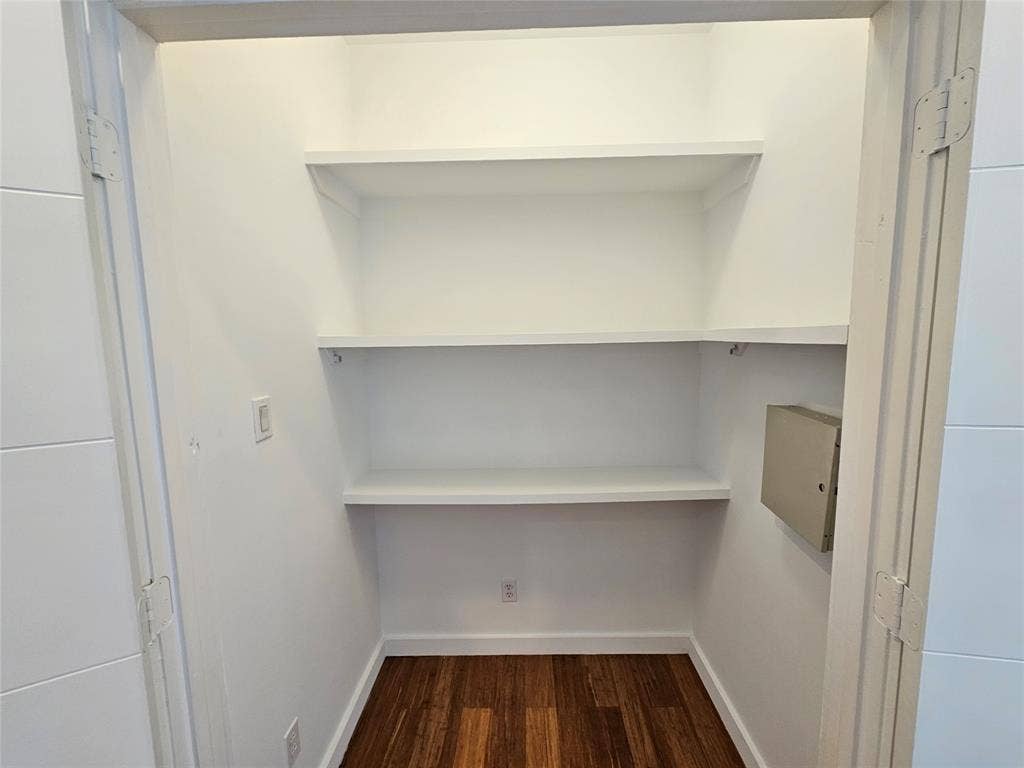 4215 Roseland Avenue, Dallas, TX 75204 Storage closet featuring wood-finish flooring, three levels of white built-in shelving, and an electrical panel