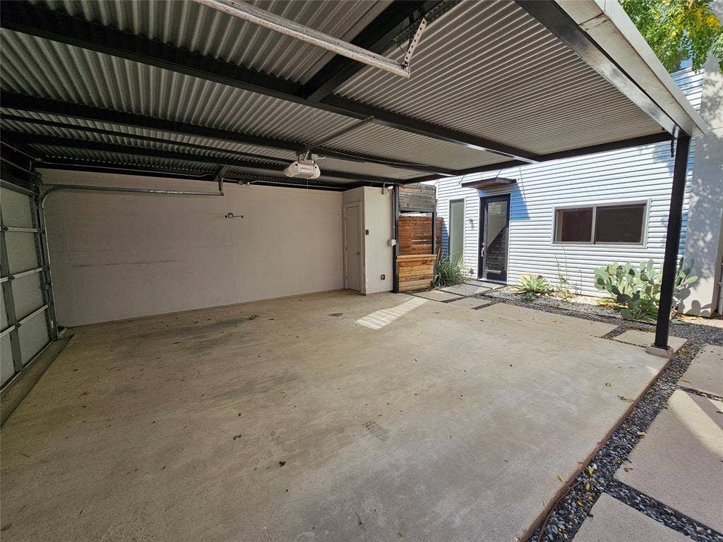 4215 Roseland Avenue, Dallas, TX 75204 Covered parking structure featuring a corrugated metal roof, black steel frame, concrete slab flooring, and exterior horizontal metal siding