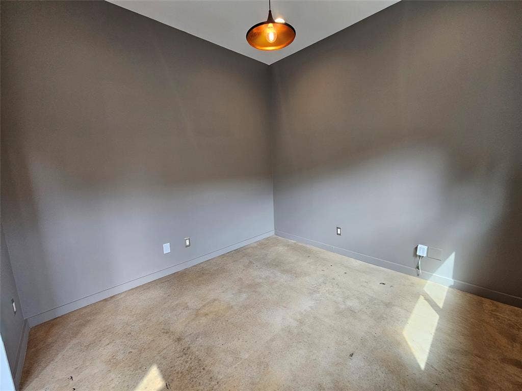 4215 Roseland Avenue, Dallas, TX 75204 Neutral-toned walls, polished concrete flooring, and a contemporary metal pendant light fixture