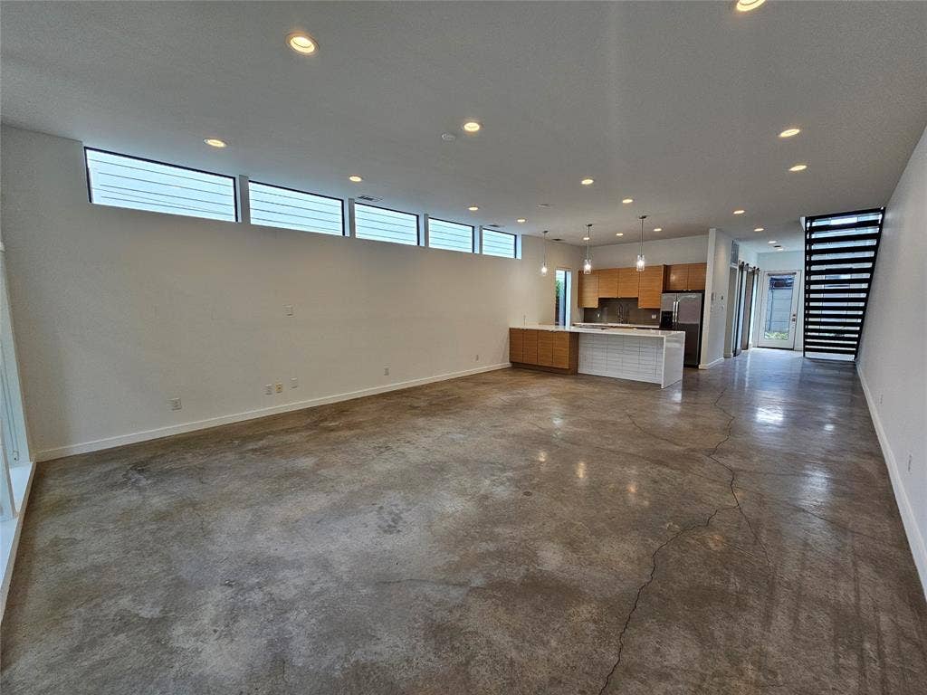 4215 Roseland Avenue, Dallas, TX 75204 Polished concrete flooring, recessed lighting, horizontal clerestory windows, kitchen featuring built-in cabinetry and an island, and metal staircase