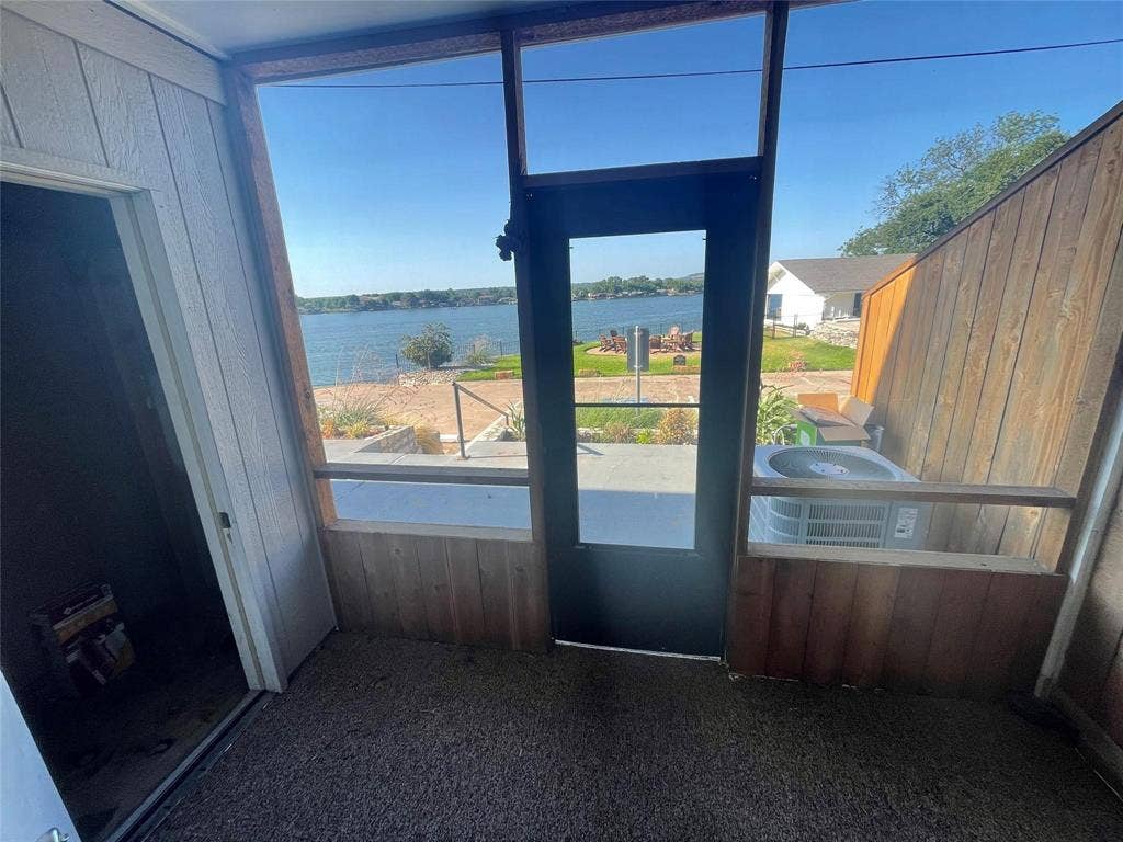 Unfurnished sunroom featuring a water view