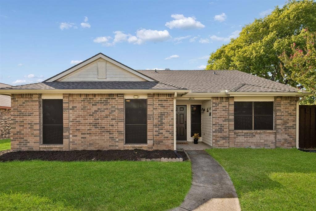 Single-story brick exterior featuring a hip roof, gabled facade detail, and a front walkway leading to a recessed entry.