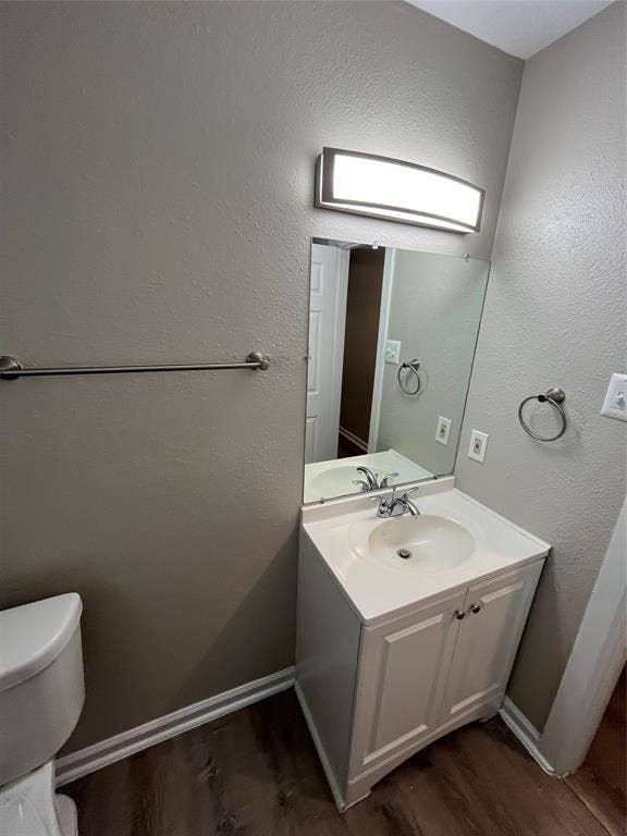 Vanity cabinet with white shaker-style doors, integrated sink, polished metal faucet, rectangular wall-mounted light fixture, and large flat mirror