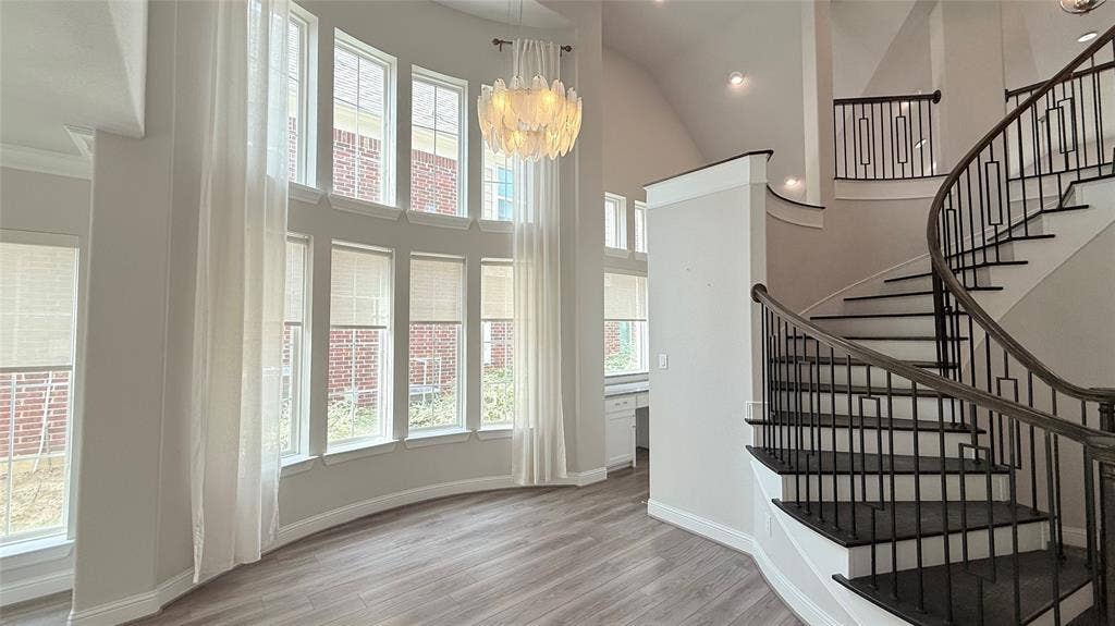 315 Chandan Way, Irving, TX 75063 Double-height windows, curved staircase with iron balusters, wood-finish flooring, and built-in desk area