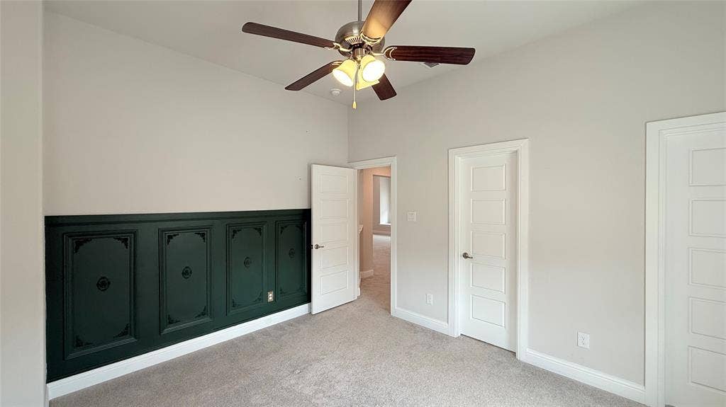 315 Chandan Way, Irving, TX 75063 Room featuring wainscoting with decorative paneling, neutral wall coloring, multi-panel doors, carpeting, and a ceiling fan with integrated lighting