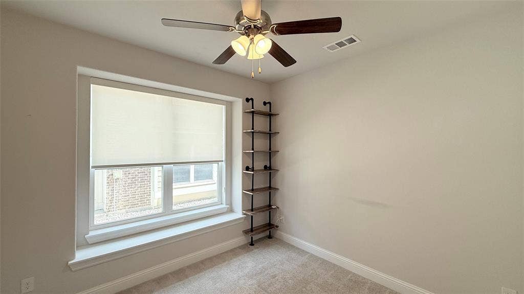 315 Chandan Way, Irving, TX 75063 Neutral-toned interior featuring wall-to-wall carpeting, a large window with deep sill, a ceiling fan with integrated light fixture, and floor-to-ceiling industrial-style wall shelving
