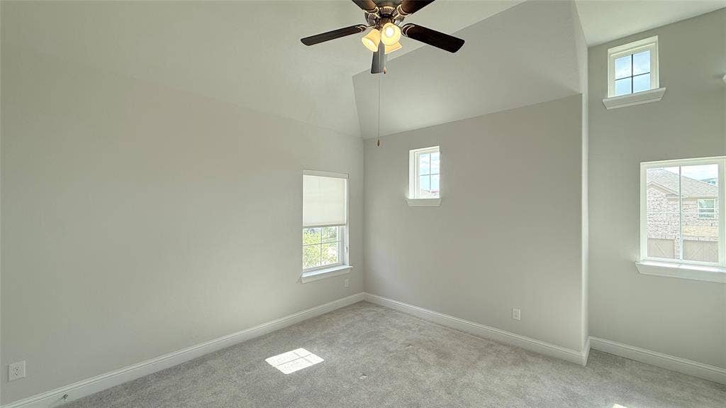 315 Chandan Way, Irving, TX 75063 Vaulted ceiling with a central multi-blade ceiling fan, neutral wall tones, carpeted flooring, and multi-pane windows