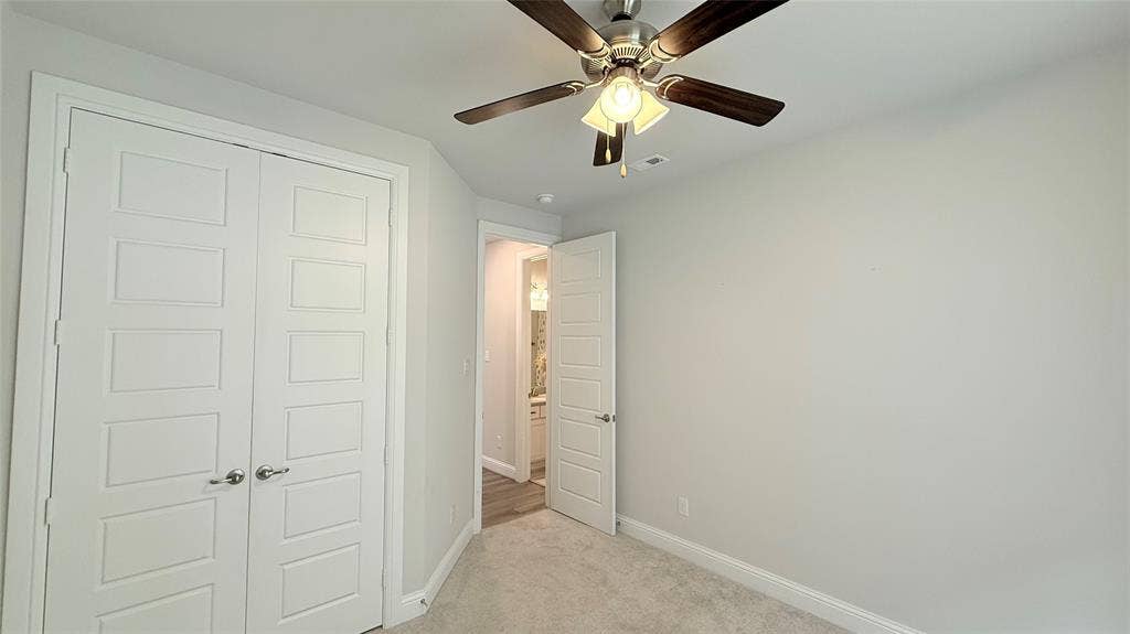 315 Chandan Way, Irving, TX 75063 Neutral-toned interior space featuring light-colored wall-to-wall carpeting, five-panel doors, and a brushed nickel ceiling fan with integrated lighting