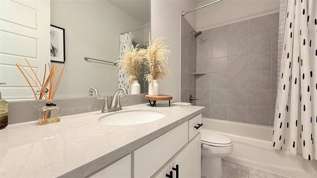 315 Chandan Way, Irving, TX 75063 Vanity with a solid-surface countertop, undermount sink, brushed nickel faucet, and shaker-style cabinetry with matte black hardware