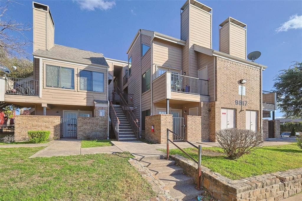 9817 Walnut Street, #213, Dallas, TX 75243 Multi-level exterior featuring horizontal lap siding, brick masonry, metal balcony railings, and vertical exterior chimneys