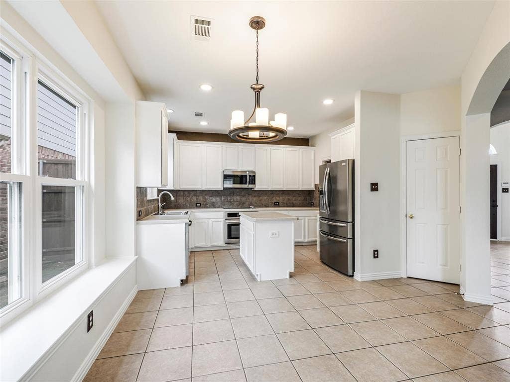 3504 Anita Drive, McKinney, TX 75070 Kitchen featuring white cabinetry, center island, stainless steel appliances, tile backsplash, and tile flooring