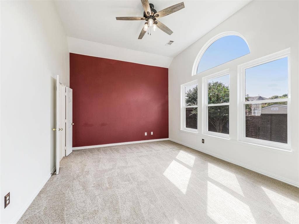 3504 Anita Drive, McKinney, TX 75070 Primary bedroom features high ceilings, an arched window, a ceiling fan with integrated lighting, and carpeted flooring