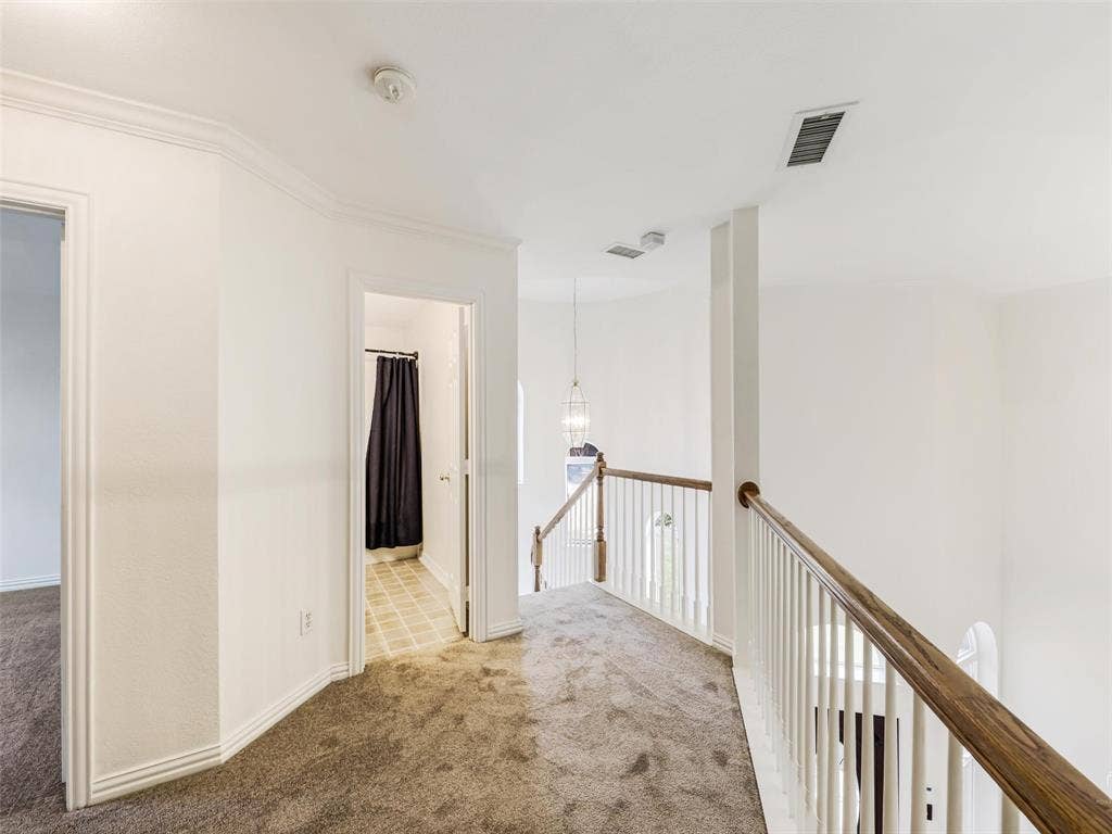 3504 Anita Drive, McKinney, TX 75070 Landing area featuring carpeted flooring, white balustrade with wood-finish handrail, and pendant lighting