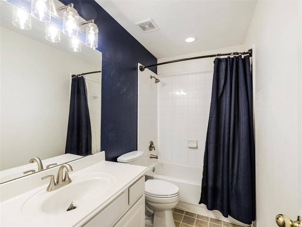 3504 Anita Drive, McKinney, TX 75070 Bathroom featuring a white vanity with an integrated sink, polished chrome faucet, full-width mirror, multi-light fixture, and a tiled tub-shower combination