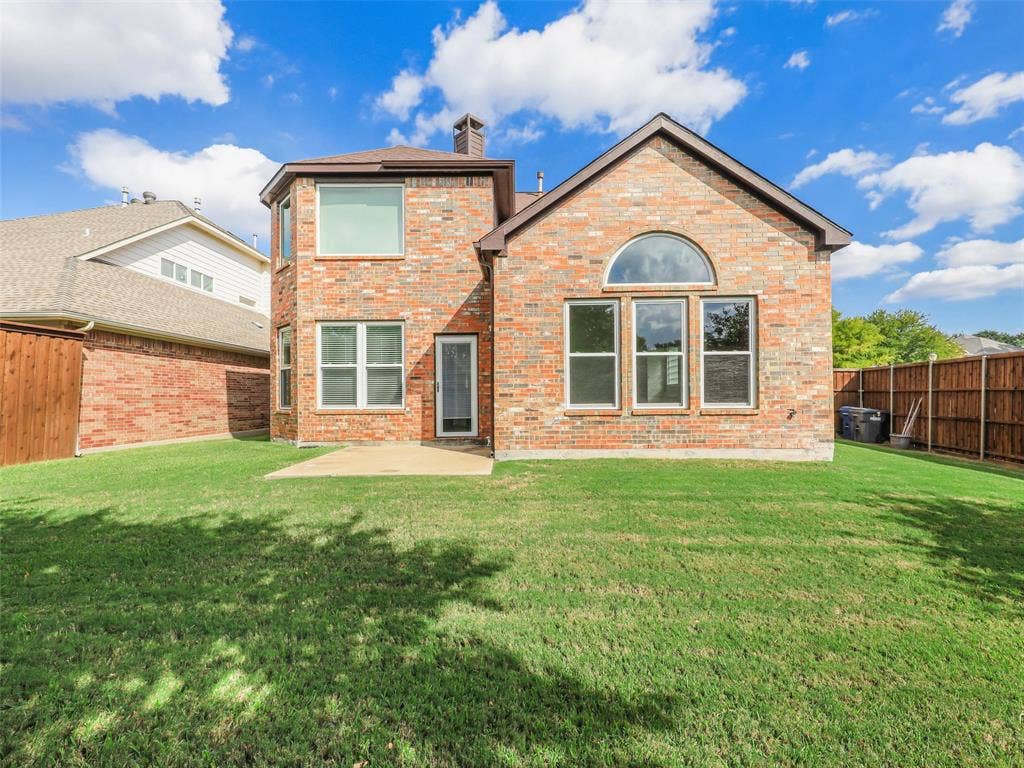 3504 Anita Drive, McKinney, TX 75070 Multi-story brick exterior featuring a concrete patio, an arched transom window, a chimney, and a fenced backyard