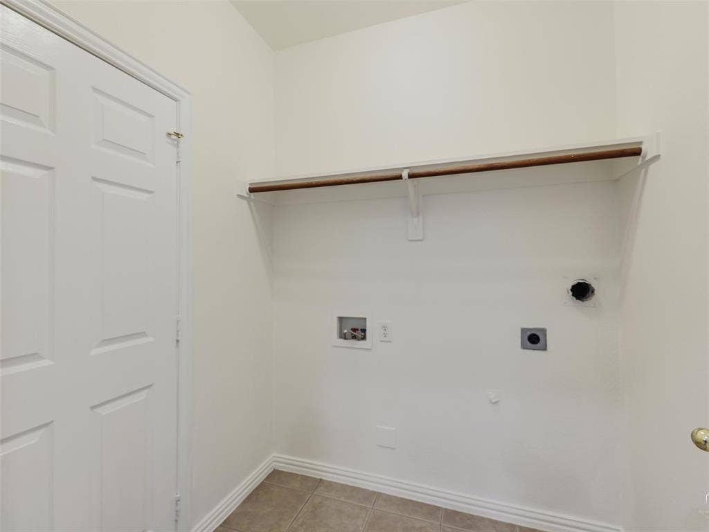3504 Anita Drive, McKinney, TX 75070 Dedicated laundry area featuring tile flooring, a built-in wall shelf with a hanging rod, and utility hookups
