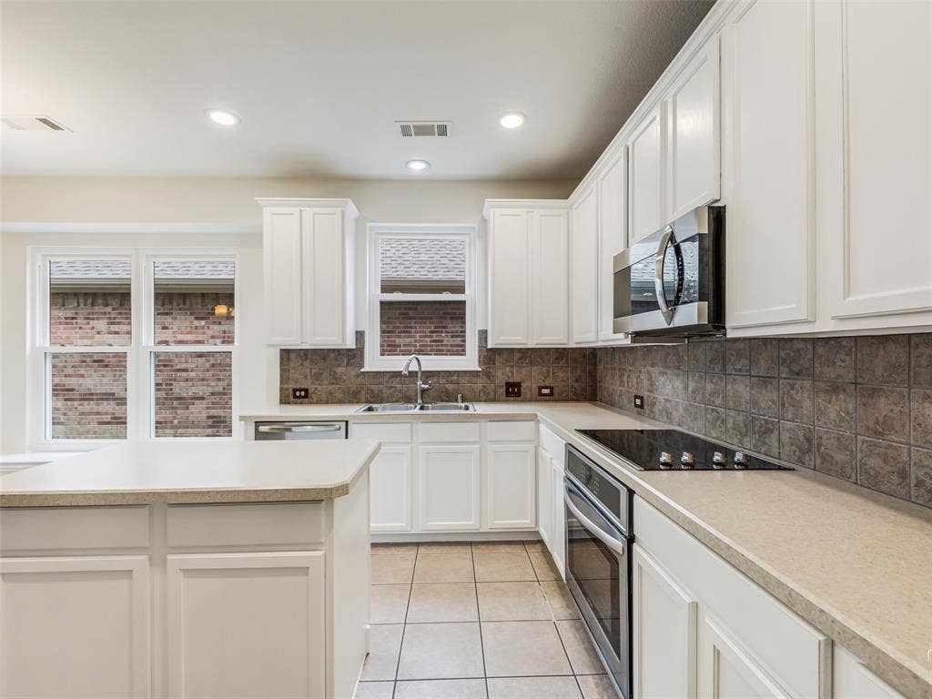 3504 Anita Drive, McKinney, TX 75070 Kitchen featuring white cabinetry, stone-finish countertops, tile backsplash, built-in stainless steel appliances, and tile flooring