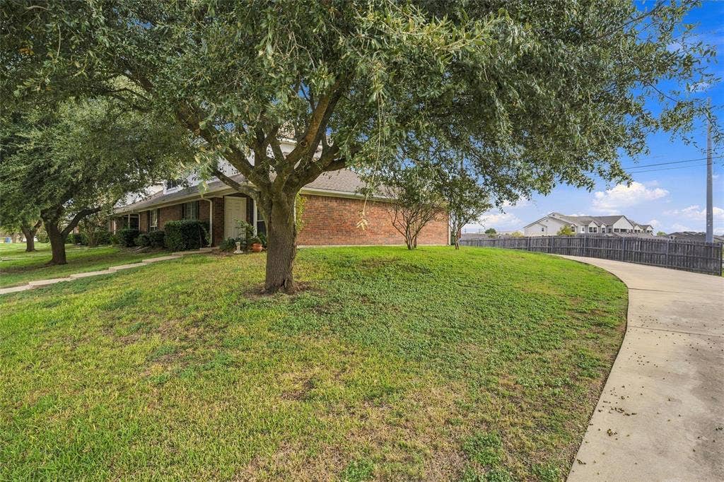 813 Chambers Creek Circle, Hewitt, TX 76643 Brick exterior, mature shade trees, expansive grass lawn, and concrete driveway