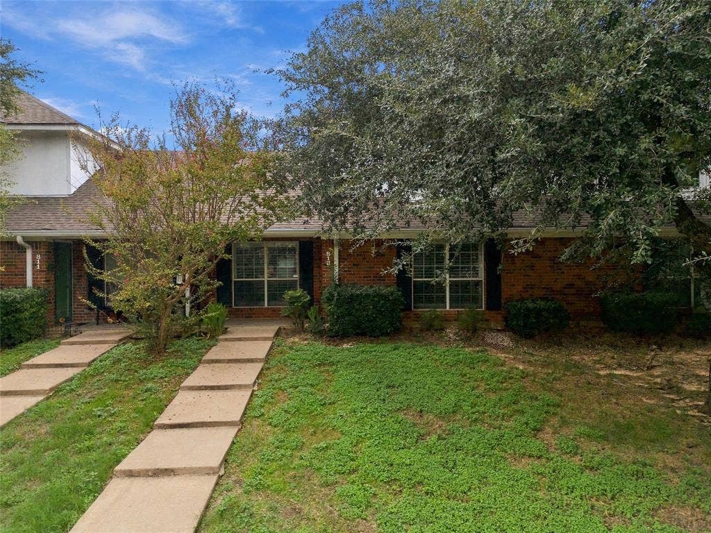 813 Chambers Creek Circle, Hewitt, TX 76643 Multi-unit red brick exterior featuring shingle roofing, dark-finished window shutters, and dual concrete walkways leading to separate entrances