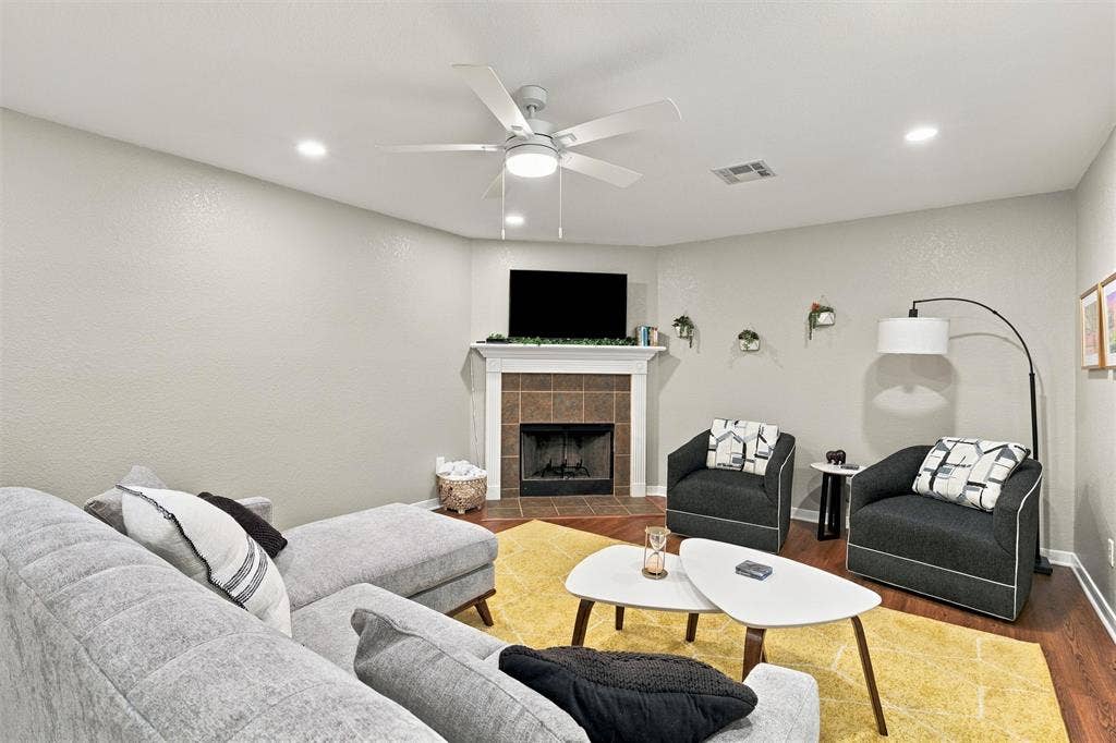 813 Chambers Creek Circle, Hewitt, TX 76643 Fireplace with a tile surround and white mantel, wood-finish flooring, and recessed ceiling lighting