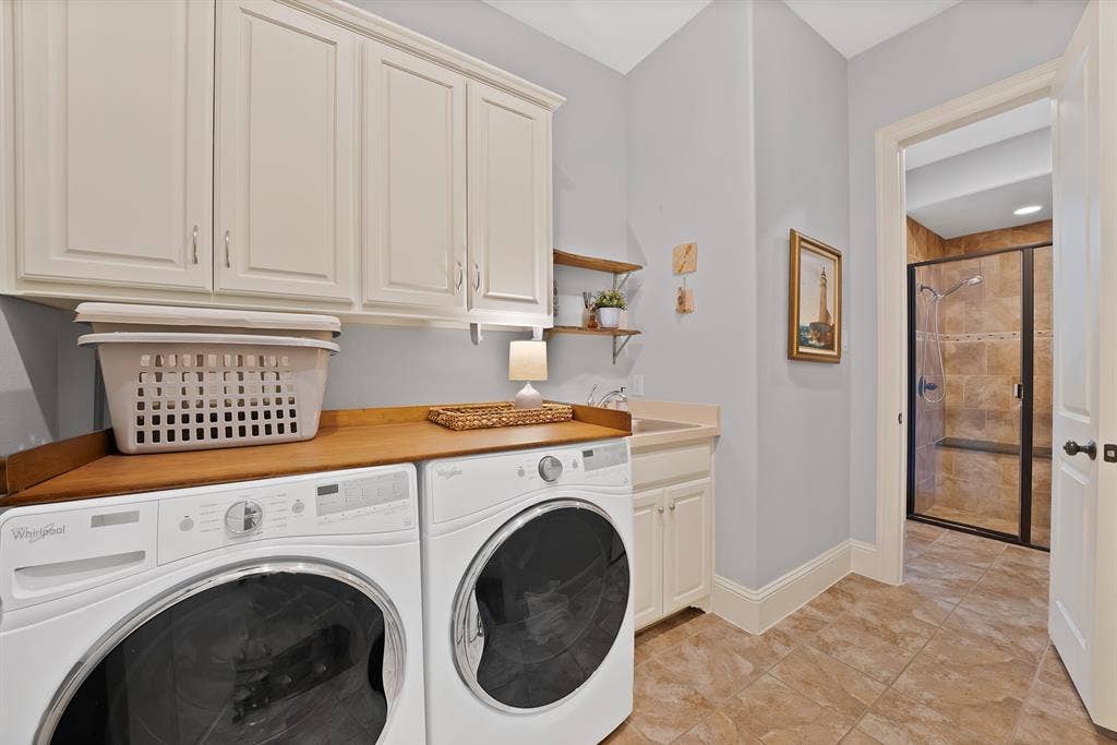 2141 Waterrock Drive, Allen, TX 75013 Laundry room featuring white cabinetry, wood-surface countertop, built-in utility sink, and tile flooring