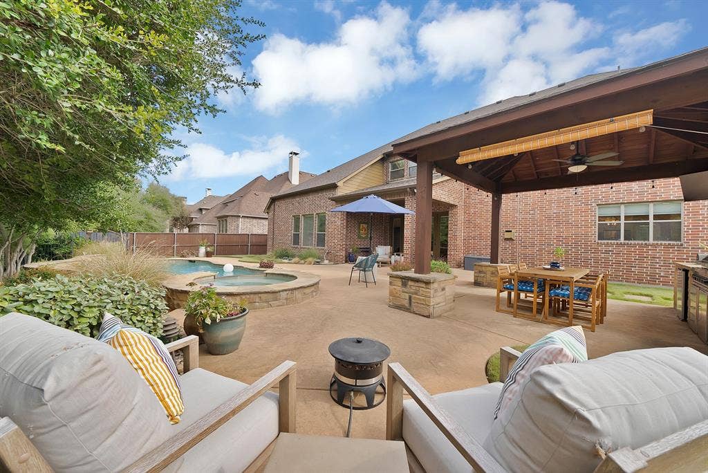 2141 Waterrock Drive, Allen, TX 75013 Brick exterior patio featuring a covered pavilion with a ceiling fan, a built-in outdoor kitchen, and an in-ground swimming pool with an integrated spa