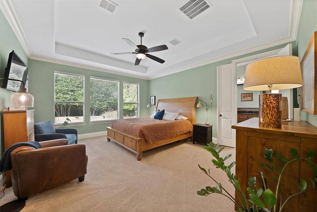2141 Waterrock Drive, Allen, TX 75013 Tray ceiling with crown molding, ceiling fan, triple windows, and neutral carpeting