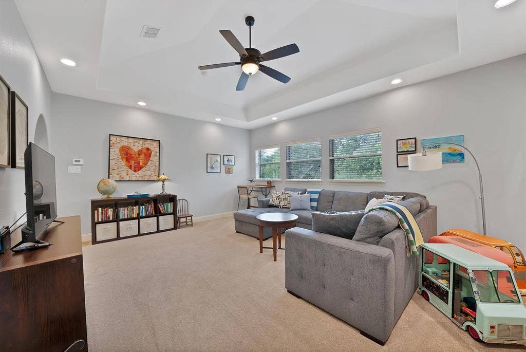 2141 Waterrock Drive, Allen, TX 75013 Tray ceiling featuring recessed lighting and a central ceiling fan, expansive triple-pane window configuration, and neutral wall tones