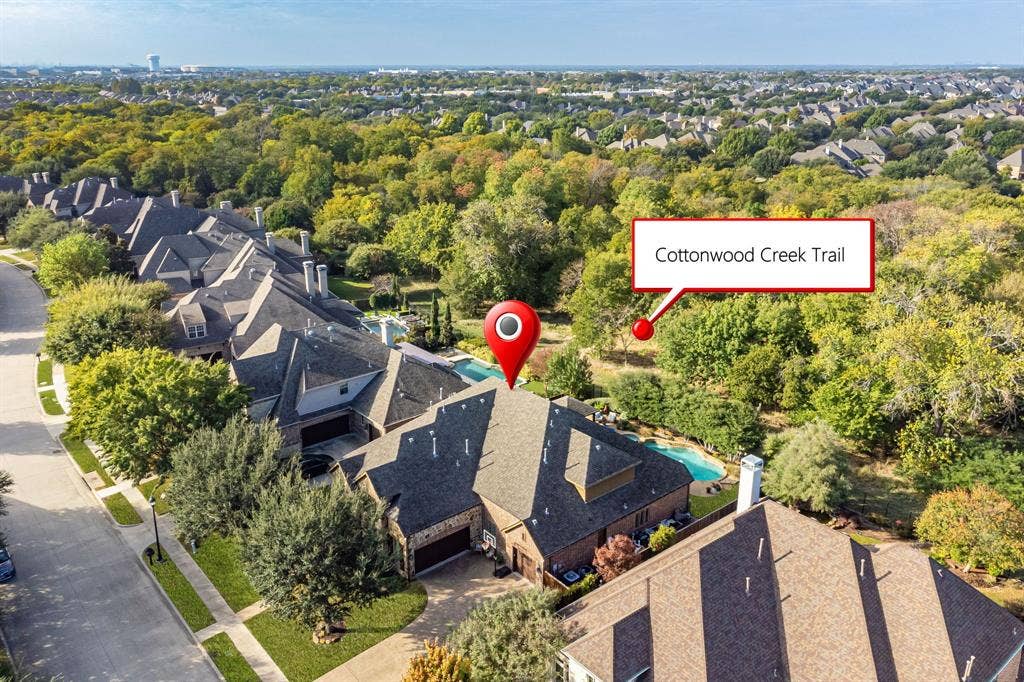 2141 Waterrock Drive, Allen, TX 75013 Aerial perspective featuring a multi-gabled roofline, private backyard swimming pool, and immediate proximity to wooded greenspace