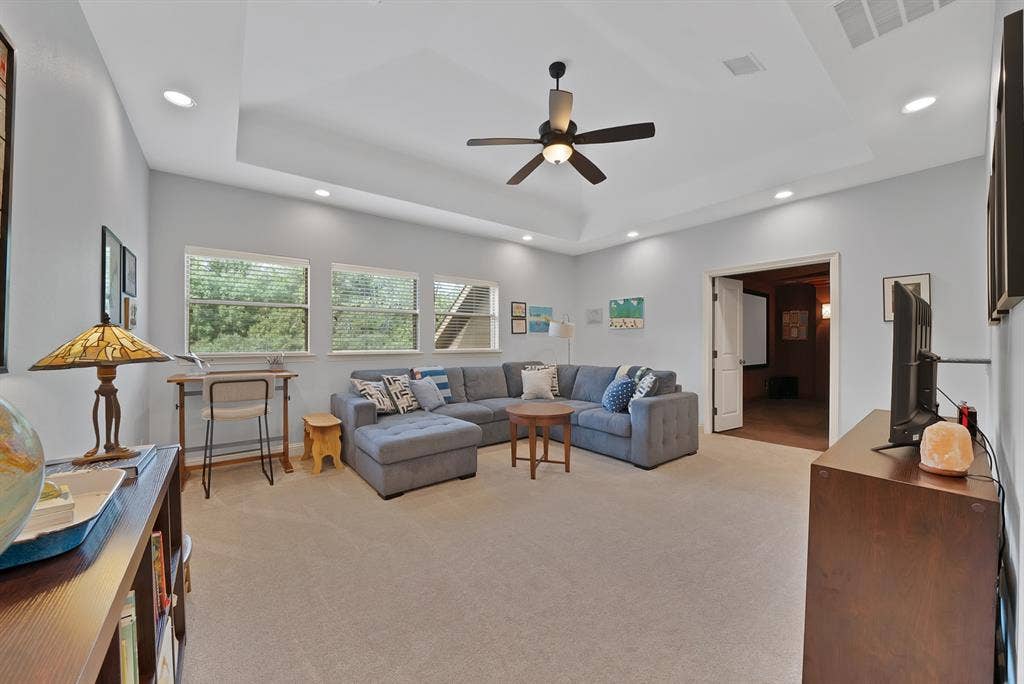 2141 Waterrock Drive, Allen, TX 75013 Tray ceiling with recessed lighting, central ceiling fan, multi-pane windows, and neutral carpeting