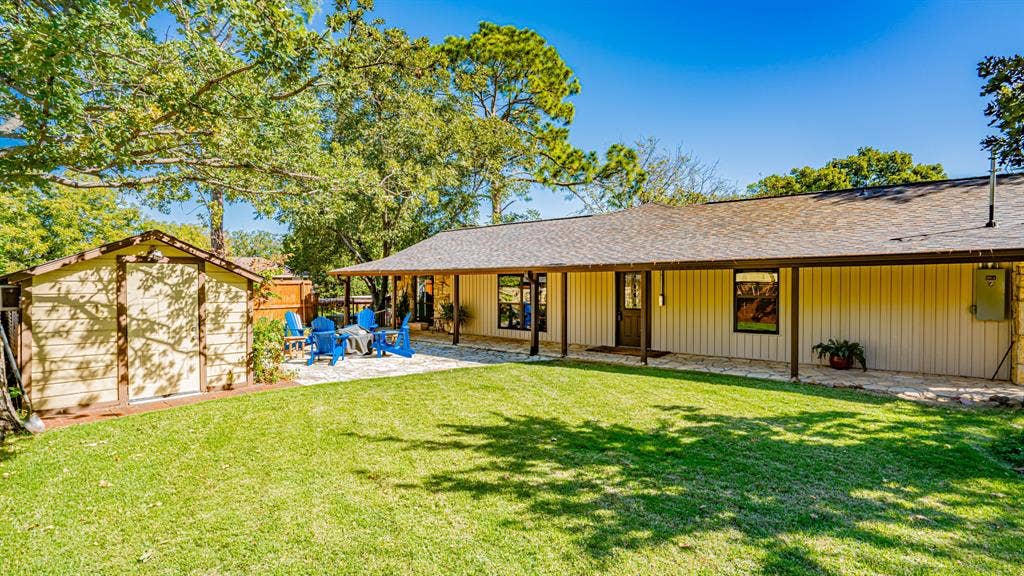 4015 Sioux Court, Granbury, TX 76048 Covered patio along house with large yard and storage building. Flagstone patio recentlly added with firepit for winter lounging.