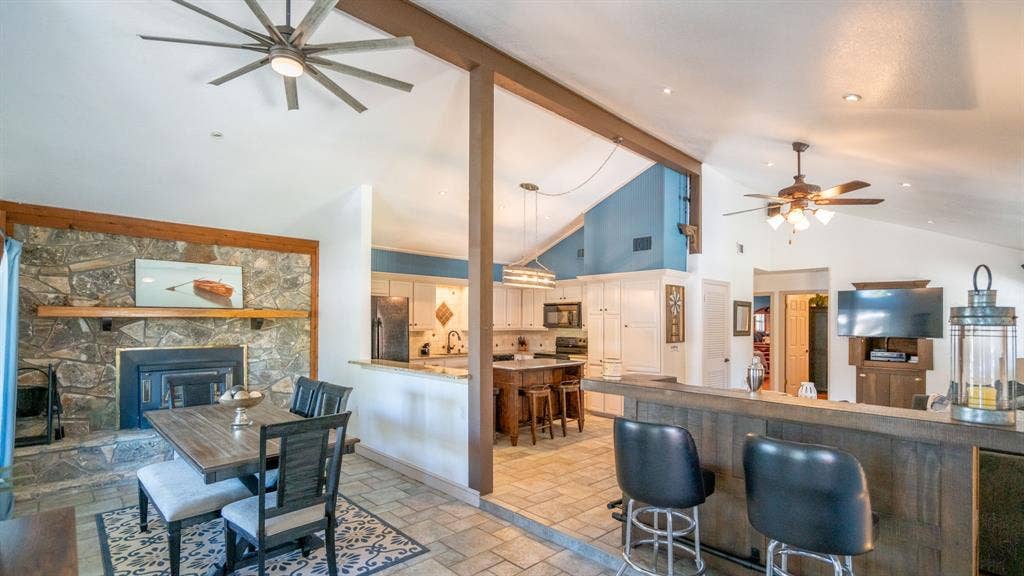 4015 Sioux Court, Granbury, TX 76048 Open layout for kitchen, dining, living areas and added bar. Wood burning fireplace and mantel for winter entertaining.