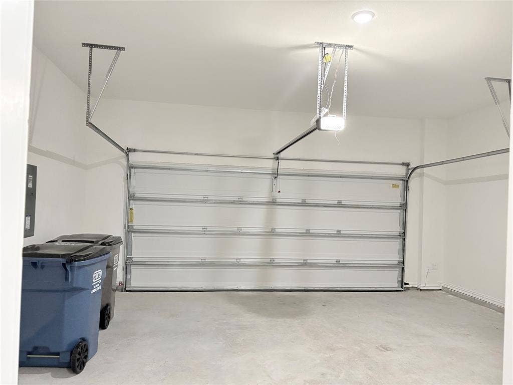 2528 Brunswick Way, Allen, TX 75013 Enclosed garage with a white sectional door, automatic opener, recessed lighting, and a concrete floor
