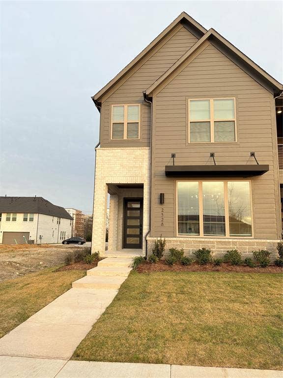2528 Brunswick Way, Allen, TX 75013 Multi-story exterior featuring horizontal siding, light-toned masonry accents, a modern multi-panel entry door, and a metal-frame window awning