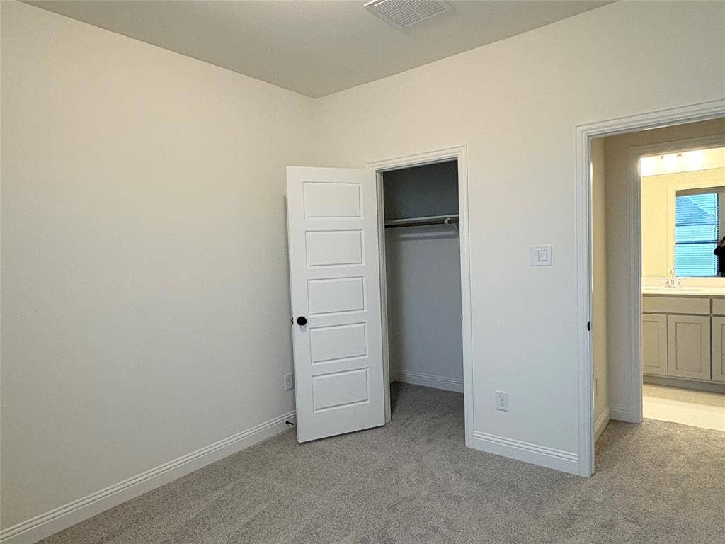 2528 Brunswick Way, Allen, TX 75013 Neutral-toned carpeting, five-panel interior door, built-in closet, and light-toned cabinetry with light-colored countertops