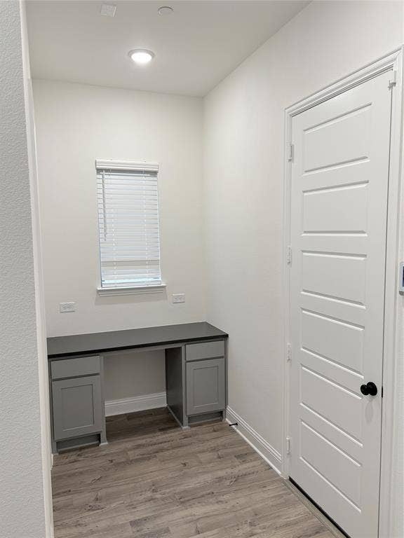 2528 Brunswick Way, Allen, TX 75013 Built-in desk featuring shaker-style cabinetry, dark solid-surface countertop, recessed ceiling lighting, and wood-finish flooring
