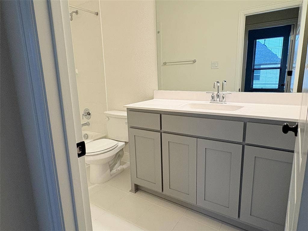 2528 Brunswick Way, Allen, TX 75013 Bathroom featuring a grey vanity with a white countertop, undermount sink, chrome faucet, full-width mirror, and a tub-shower combination