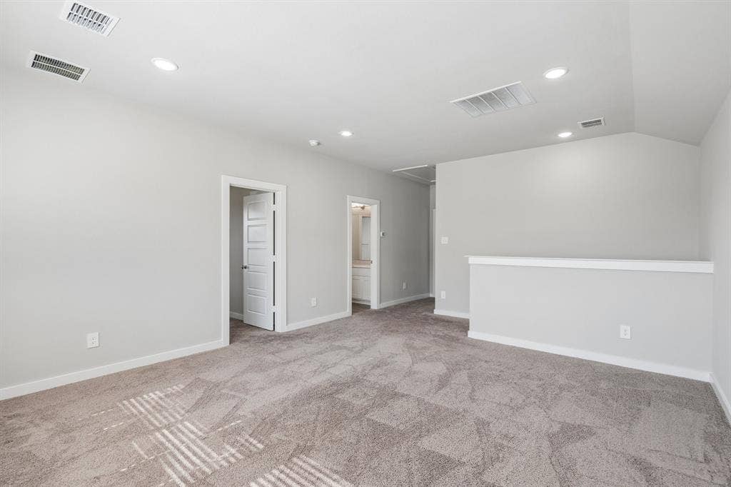 135 Lost Maples Way, Waxahachie, TX 75165 Neutral-toned carpeted flooring, vaulted ceiling, recessed lighting, and four-panel interior doors