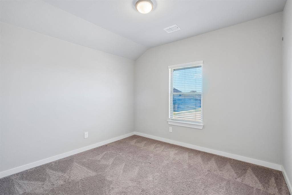 135 Lost Maples Way, Waxahachie, TX 75165 Neutral-toned interior featuring wall-to-wall carpeting, a single-pane window with horizontal blinds, and a vaulted ceiling with a flush-mount light fixture