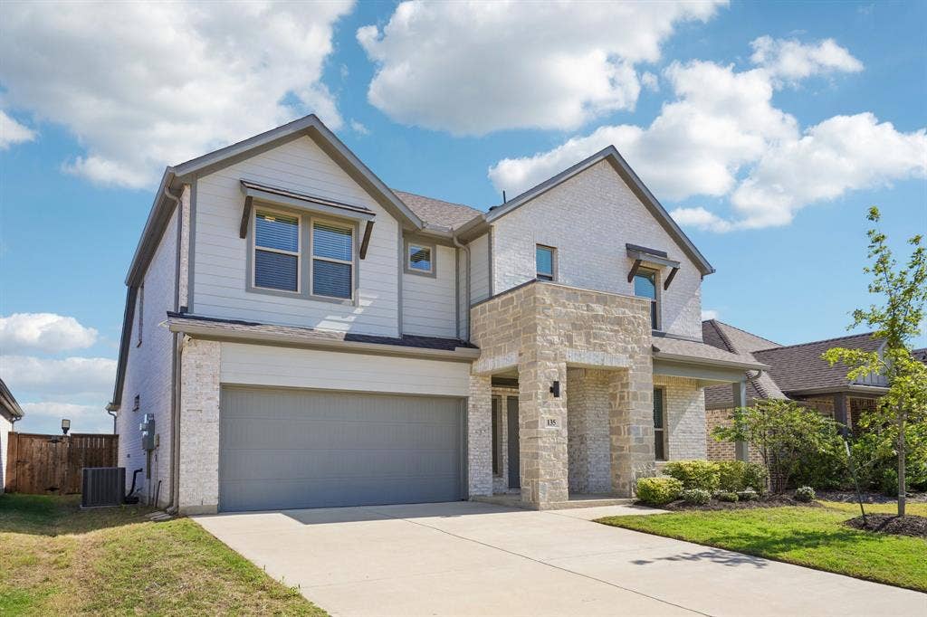 135 Lost Maples Way, Waxahachie, TX 75165 Two-story exterior featuring a combination of light-toned masonry and horizontal siding, a covered entryway, and a dual-car garage